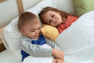 Adorable girl and boy smiling confident lying on bed at bedroom