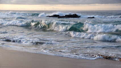 Waves breaking around a rock off a beach in Zipolite, Mexico