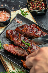 cut the steak with a knife on a dark background. American food concept. banner, menu, recipe place for text, top view