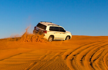 Fototapeta na wymiar Offroad safari in sand desert, Empty Quarter Desert in United Arab Emirates. Offroader on dunes in Rub’ al Khali desert. Sand and sky.
