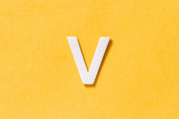 Letter V of the alphabet isolated on yellow background, top view