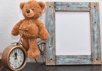 bear toy sits on decorative bicycle clock near vintage wooden frame