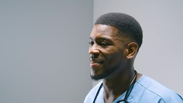 Black Stock Footage of millennial Black man nurse smiling, working, and being productive at his office desk in the hospital