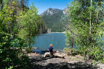 Girl fishing on the lake shore