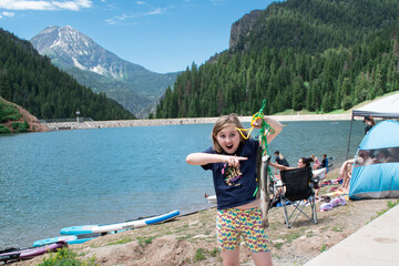 Excited Girl fishing at a mountain lake