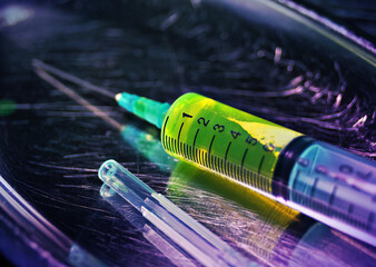 Green drug liquid inside a plastic syringe. Vaccination, research and medical social issues concept