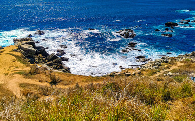 Beautiful rocks cliffs view waves at beach Puerto Escondido Mexico.