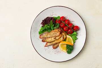 Fried Tilapia fish fillet, in spices, with cherry and salad, on a white plate, homemade, no people,