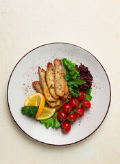 Fried Tilapia fish fillet, in spices, with cherry and salad, on a white plate, homemade, no people,