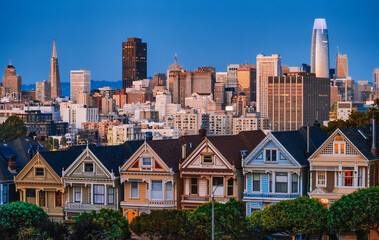 Fototapeta na wymiar Painted Ladies Victorian houses in Alamo Square and a view of the San Francisco skyline and skyscrapers. Photo processed in pastel colors
