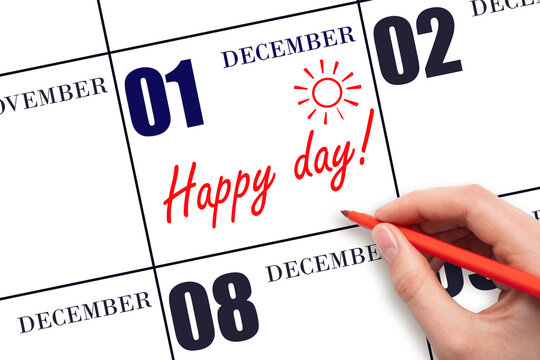 Hand writing the text HAPPY DAY and drawing the sun on the calendar date December 1
