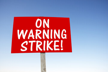 On warning strike, sign with slogan