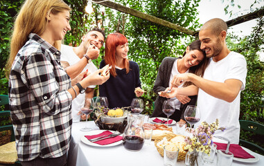 Happy people having fun eating at restaurant garden  party - Lifestyle concept with friends drinking wine together at farmhouse vineyard winery