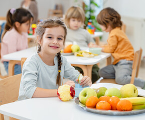 Children eating a fruit snack in a kindergarten 