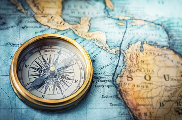 Magnetic compass on world map. Travel, geography, navigation, tourism and exploration concept background. Macro photo. 