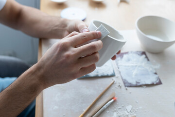 Close-up Image of male hands working with clay mug and making Ceramic Product. Professional Ceramic Artist makes handcrafted products. Small business and hobby concept