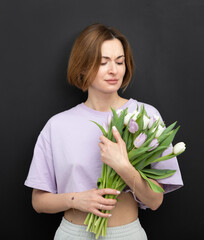 Happy woman holding a bouquet of flower isolated on black background