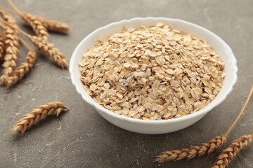 Oatmeal in bowl on grey background. Healthy eating concept.