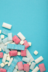 Different chewing gums on blue background. Vertical photo