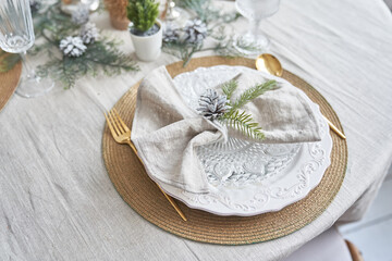 Winter holiday theme, design with copy space. Close-up of the Christmas serving, plate, spoon and fork, on a table with a light tablecloth, top view. High quality photo