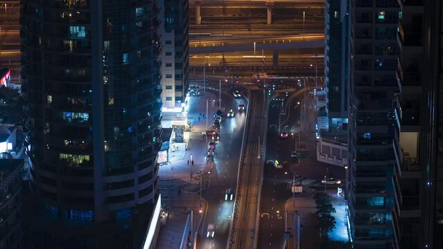 Timelapse, 4k, aerial view of the urban landscape of a modern night city, people move along the street, cars move along the road