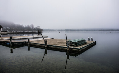 A boat jetty on a foggy winter day at Reifnitz am Worthersee on the south shore of Worthersee, or Worth Lake, in Carinthia, Austria
