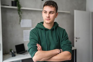 one man teenager stand in room at home wear green hoodie waist up