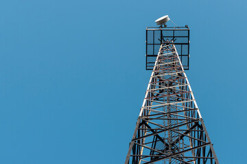 Radio relay antenna on a metal tower. Against the background of the blue sky
