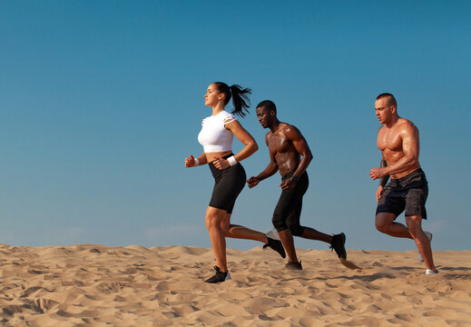 A team of athletes with athletic body in the summer outdoors go in for sports, jogging and running. Download a photo to advertise on social networks, sports running magazines and fitness websites.