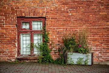 Red brick wall with an old wooden window. Atmospheric  view in the old town