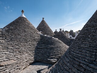 Fototapeta na wymiar Stone cone roofs of historical houses in Alberobello, Italy