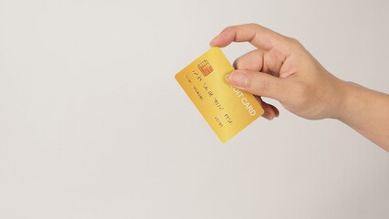 Hand is holding gold credit card isolated on white background..