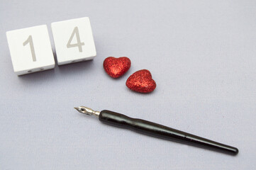 Cubes with numbers, red hearts and a fountain pen on a light background. Valentine's Day Greeting Card