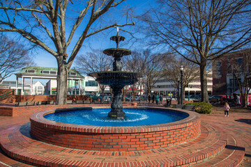 A gorgeous winter landscape at the Marietta Square with red brick footpath, a water fountain, bare...