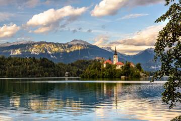 Fototapeta na wymiar Church on island, lake and mountains background at Bled, Slovenia