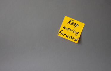 Keep moving forward symbol. Concept words keep moving forward on orange steaky note. Beautiful grey background. Business and keep moving forward concept. Copy space.