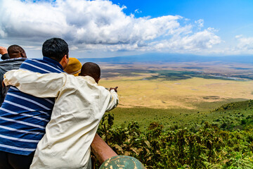 View of the Ngorongoro crater in Tanzania. Ngorongoro conservation area. African landscape. Guide showing something to tourists - obrazy, fototapety, plakaty
