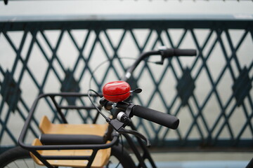 Fototapeta na wymiar bicycle with red bicycle bell in front of black fence