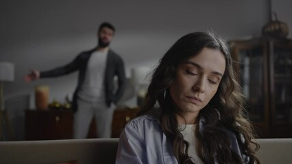 Selective focus on young married couple arguing over relationship in raised voices.