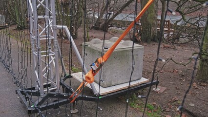 Tall Truss Construction Supported By Heavy Concrete Block Ballast and Strong Flat Polyester Belt...