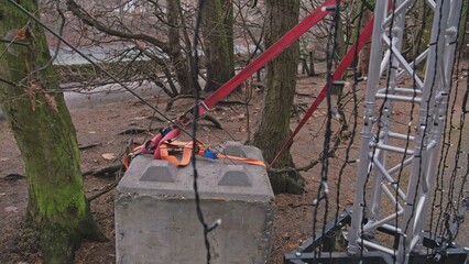 Tall Truss Construction Supported By Heavy Concrete Block Ballast and Strong Flat Polyester Belt...