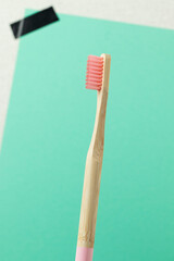 Bamboo toothbrush with pink bristles on blue background.