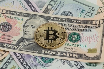 Golden bitcoin coin on a paper dollars money