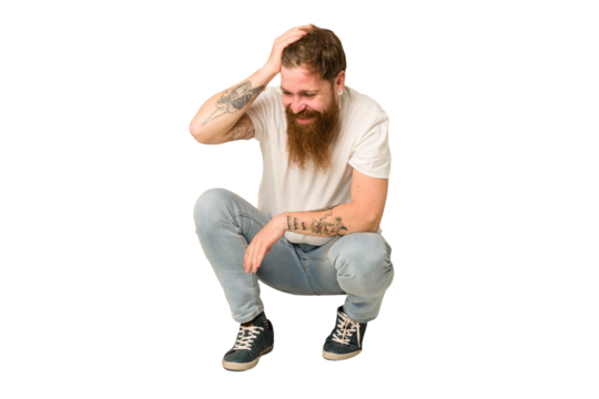 Adult redhead man sitting on the floor isolated