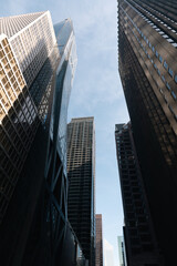 Naklejka premium low angle view of facades of high-rise buildings in midtown of New York City.