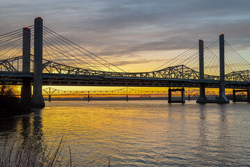 Fototapeta na wymiar John F. Kennedy Bridge and Abraham Lincoln Bridge crossing the Ohio River between Louisville, Kentucky and Jeffersonville, Indiana at sunset.