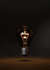 Classical style lightbulb E27. Hovering over studio floor. Burning softly. Idea metaphor. Glowing thread. Dark room