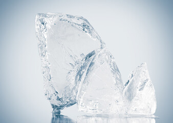 A pieces of natural textured clear blue crushed ice with cracks on a white reflective surface.