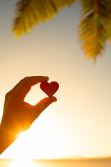 Close up of heart on a colorful ocean sunset background. Love nature concept.	