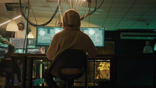 Team of hackers applauding young thief about hacktivism success, celebrating illegal activity achievement at night. Cyber criminals feeling happy about successfully stealing government data.